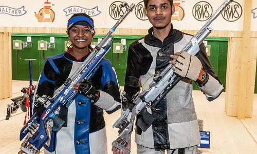 Elavenil Valarivan and Divyansh Singh Panwar with their guns for shooting event