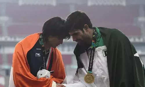 Indias Neeraj Chopra and Pakistans Nadeem Arshad share a warm moment on the victory podium at the 2018 Asian Games [Source: AP]