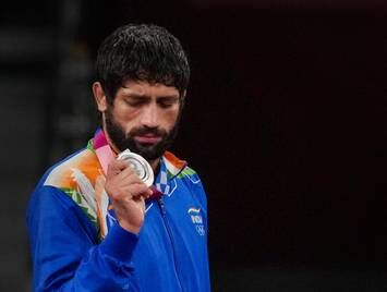 The champion wrestler looks at his medal won by a champion performance (Source: Getty Images)
