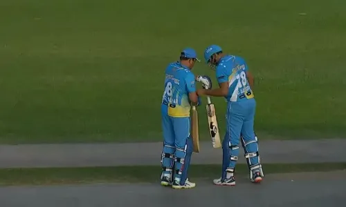 Mohammad Azharuddin and Asaduddin exchanging bats in the middle of 2022 Friendship Cup match