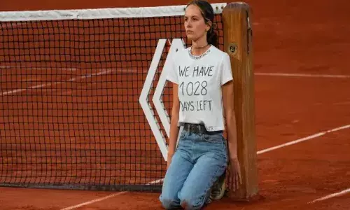 A climate activist protested at the net during the French Open mens singles semi-final (Source: AP)