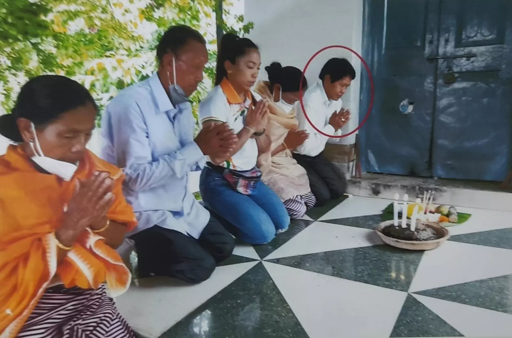 Anita Chanu (right) prays with Mirabai Chanu and her parents
