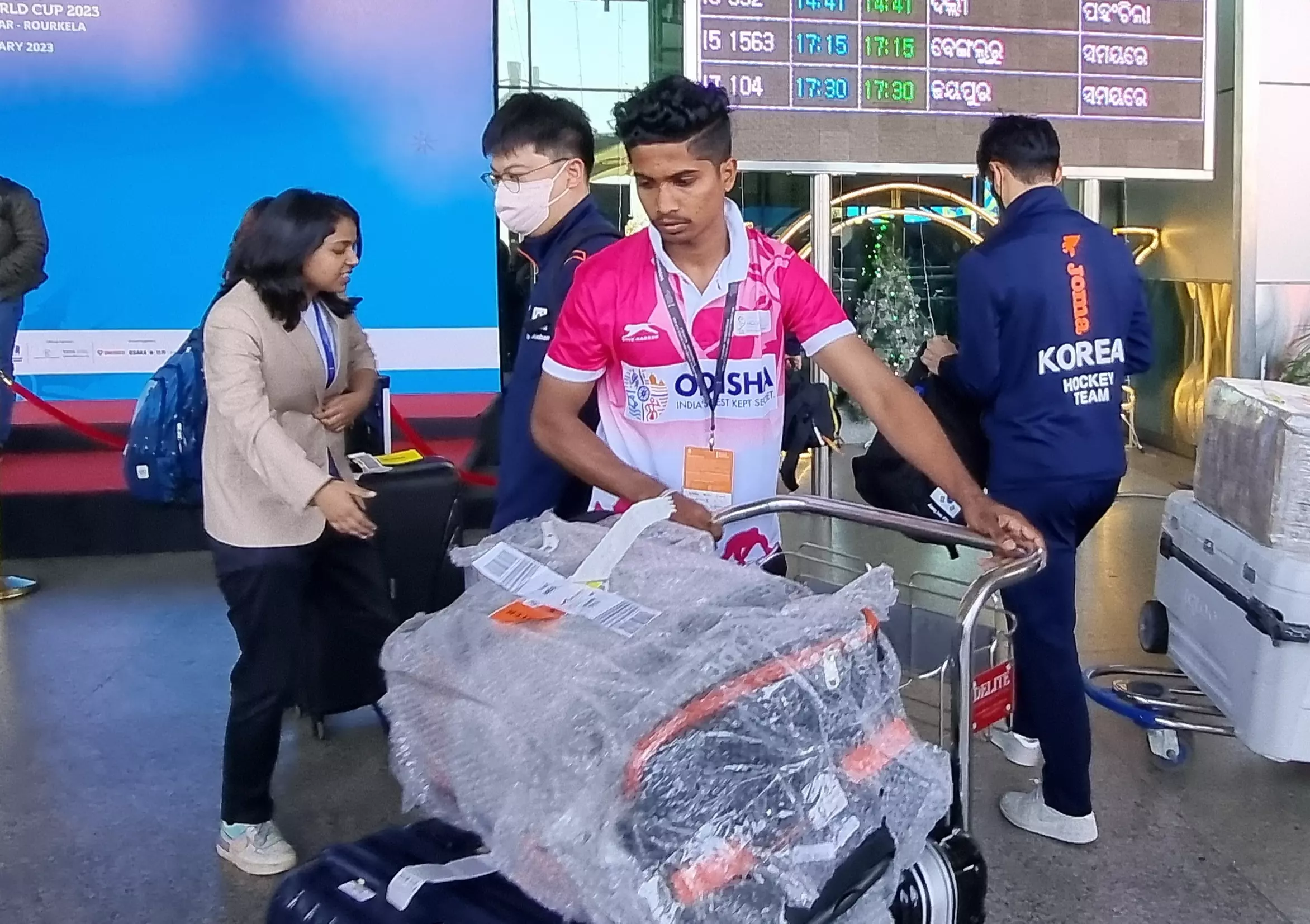A volunteer helps the South Korean team with their luggage upon their arrival in Bhubaneswar