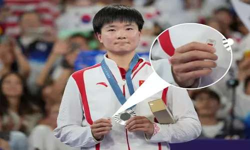 With a small pin in hand, He Bingjiao upholds the true spirit of Olympics