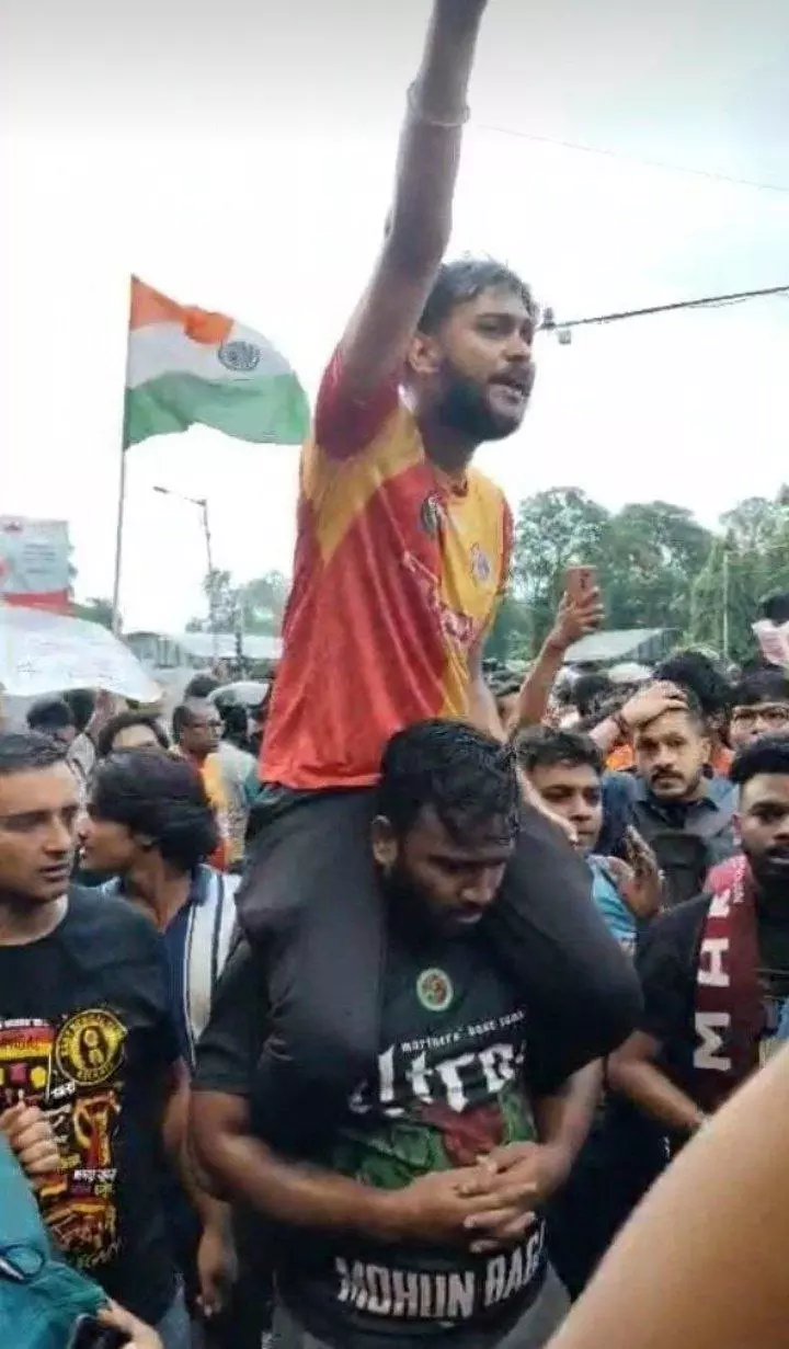 Moment of Solidarity: A Mohun Bagan fan carrying an East Bengal supporter during Sundays protest in Kolkata.