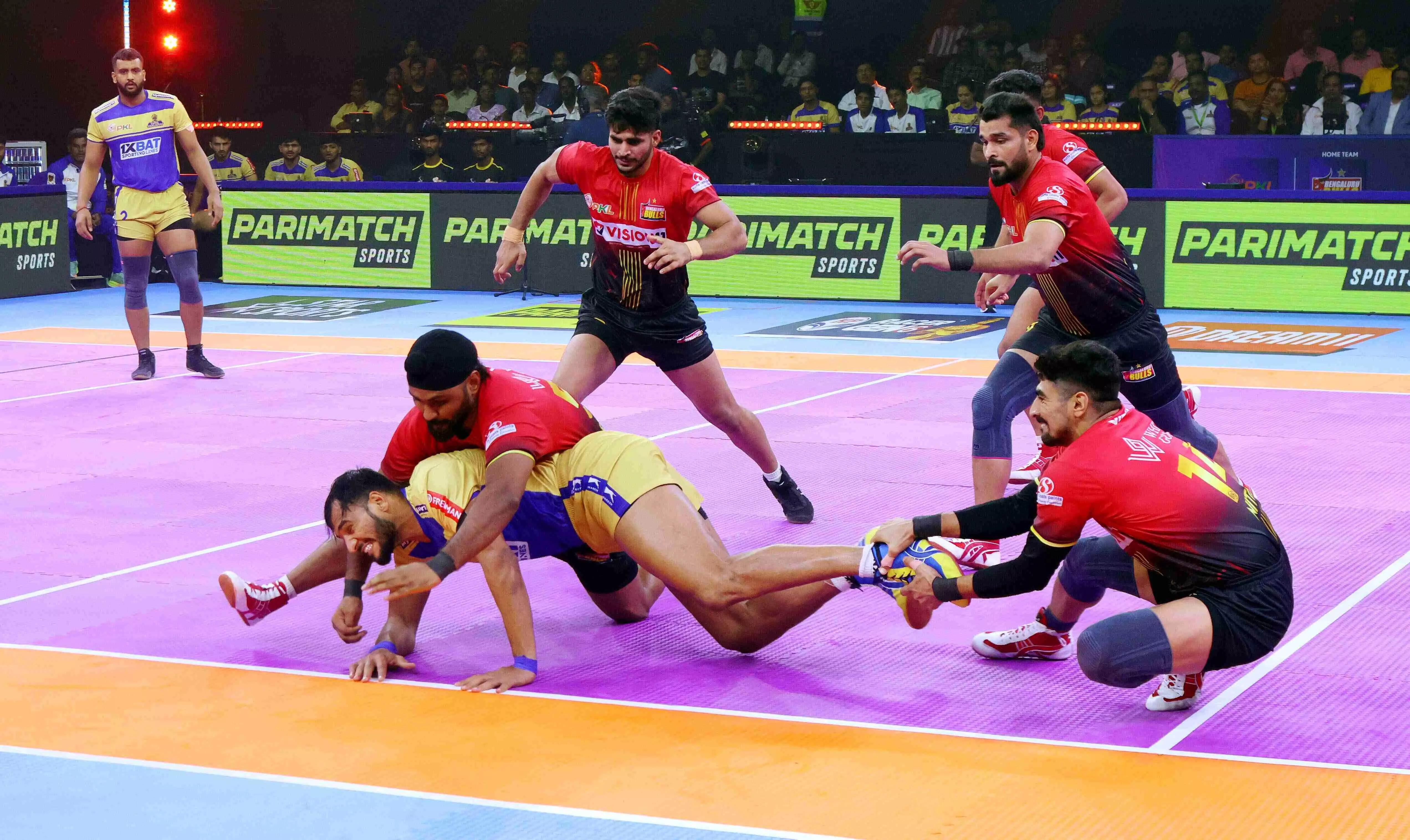 Bengaluru Bulls players take down a Tamil Thalaivas rider. 